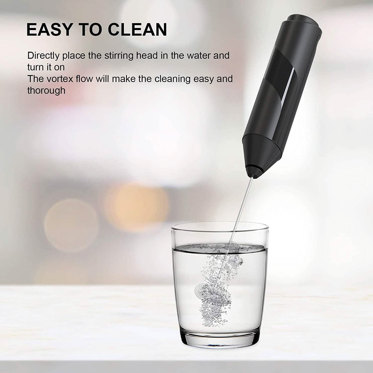 Milk frother whisk spinning in a glass of water demonstrating easy cleaning